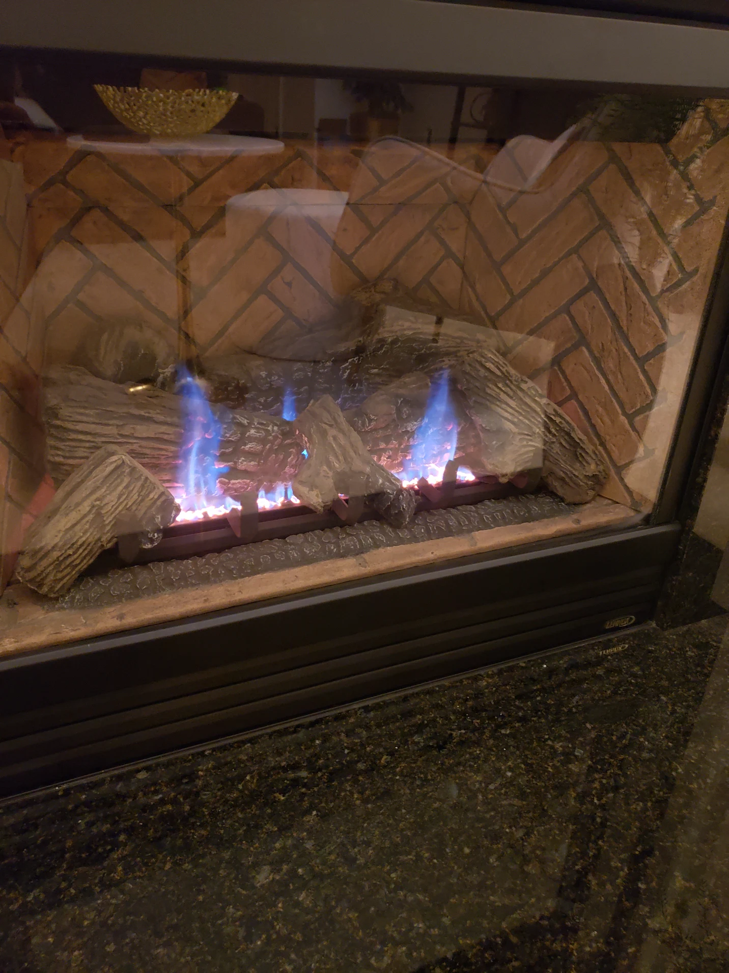 Black gas fireplace with TV and custom brickwork